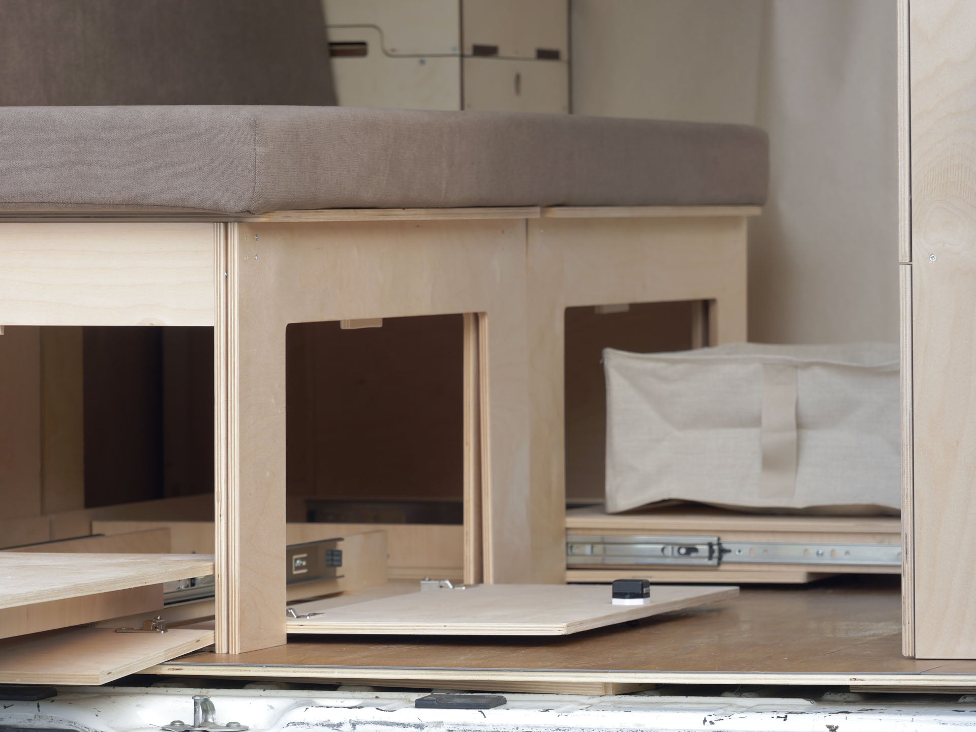 Dettaglio della guida del piano estraibile frontale del Letto Nom Outdoor, sistema scorrevole per camperizzazione van modulare.