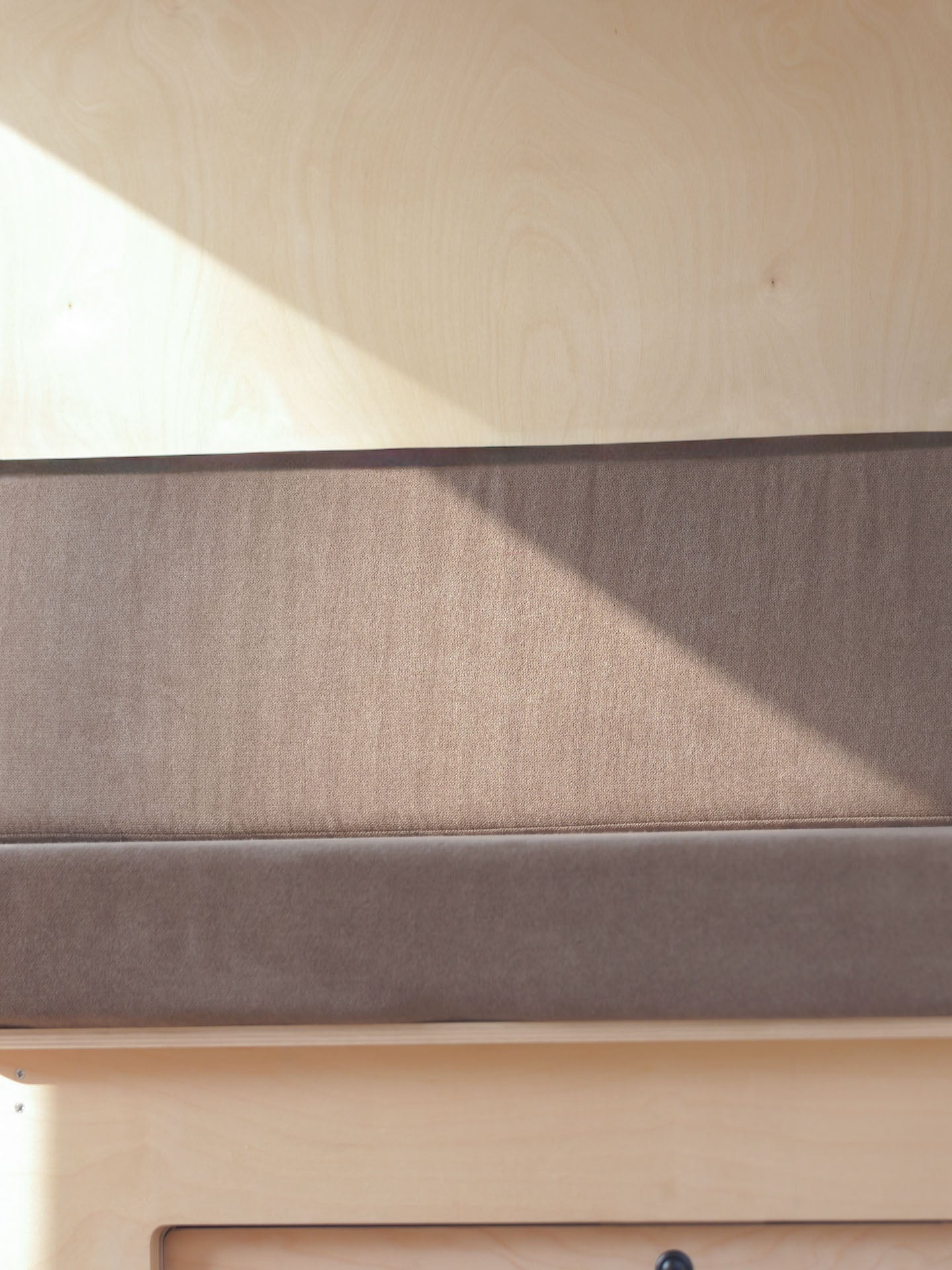 Dettaglio del materasso van Nom Outdoor colore grigio montato sul letto modulare, soluzione per camperizzazione van con rivestimento sfoderabile.