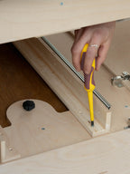 Dettaglio di cacciavite che fissa il piano estraibile laterale del Letto Nom Outdoor, sistema modulare per camperizzazione van con accesso laterale allo stivaggio