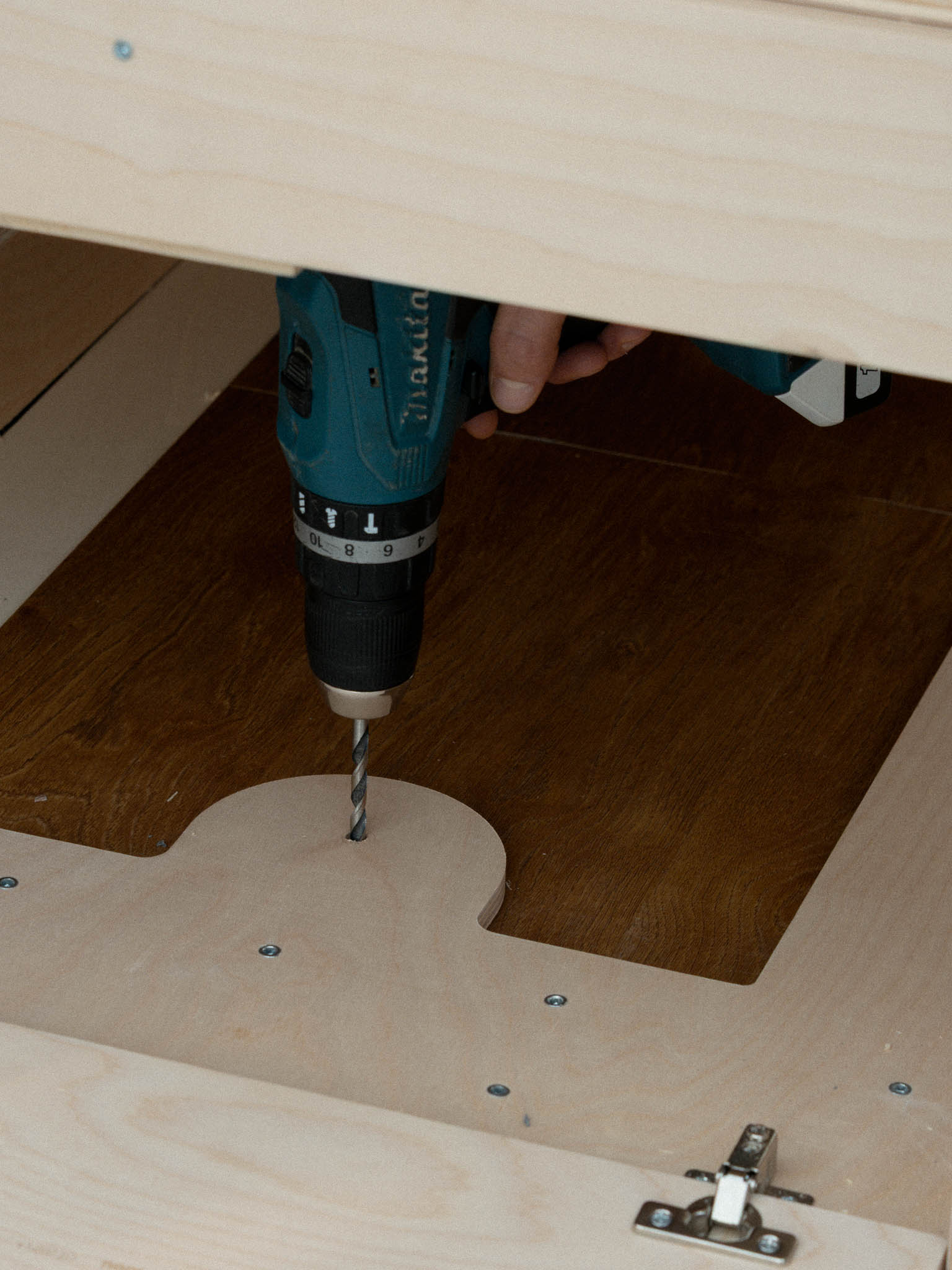 Trapano che fora il pianale del furgone per l’inserimento della bussola del sistema di fissaggio Nom Outdoor, soluzione sicura per ancorare i moduli della camperizzazione van