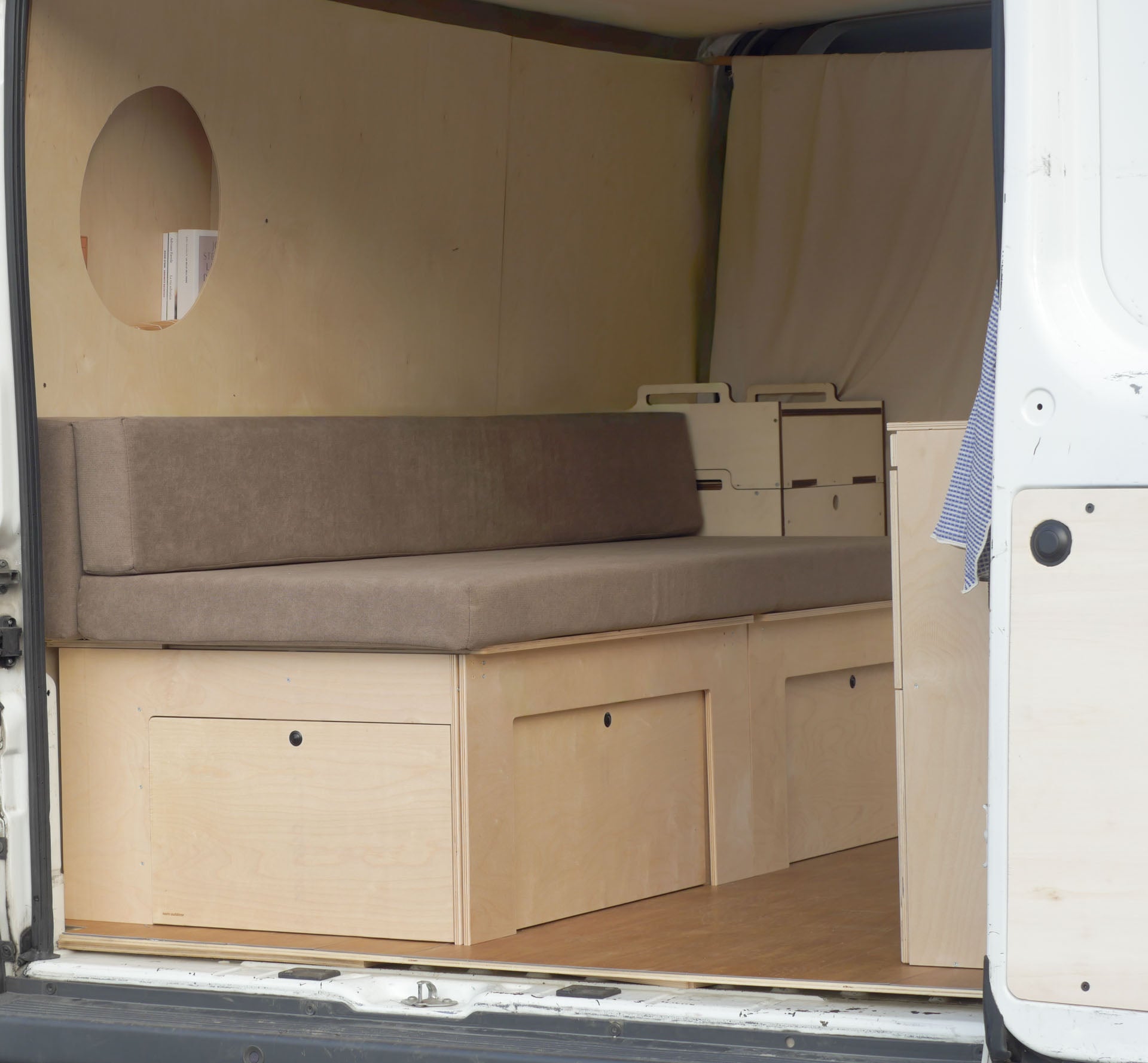 Vista in prospettiva del Letto Nom Outdoor con sistema Totem e materasso modulare installato, soluzione completa per camperizzazione van componibile.