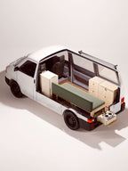 Render 3D del Nom Total Kit con cucina modulare estratta all’esterno del van tramite piano estraibile, configurazione completa per camperizzazione van.