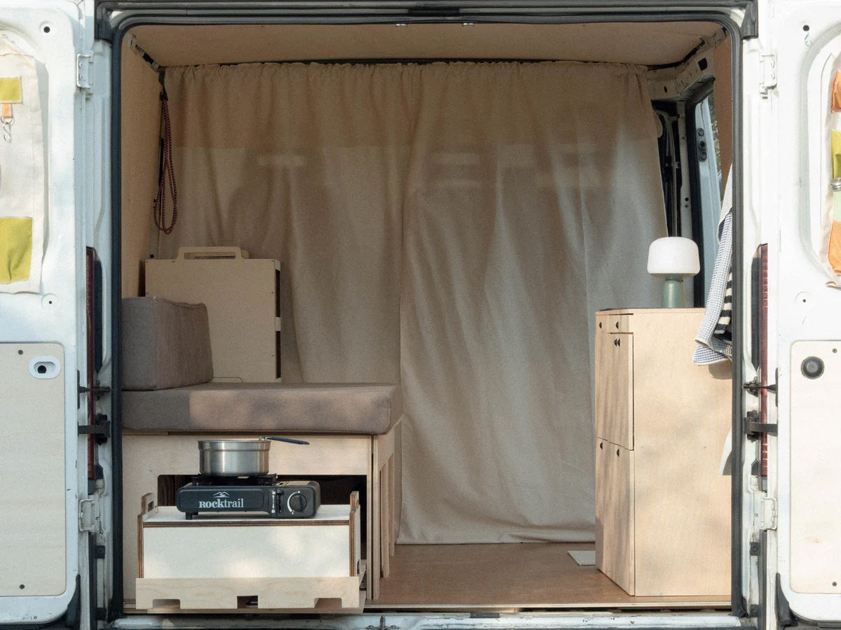 Nom Total Kit con Totem Cook posizionato sul piano estraibile laterale, soluzione completa di camperizzazione van con cucina modulare pronta per cucinare.