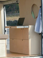 Nom Van Storage S con tavolo estraibile utilizzato come piano di lavoro con PC, modulo storage per camperizzazione van ideale per van life e smart working.